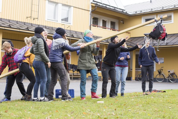 Studerande i folkhögskola gör gruppövningar ute på gården.