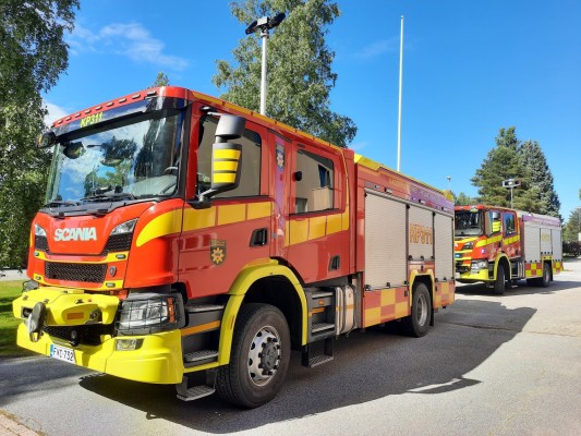 Kaksi uutta, punakeltaista paloautoa Kruunupyyn kunnantalon edessä.